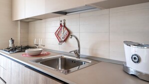 A modern kitchen with a stainless steel sink, a gas stove, and a toaster. - Holiday Apartment "Villa Katia - Villanova di Ostuni" with Private Terrace and Wi-Fi (Villanova di Ostuni)
