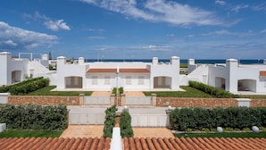 A modern building with multiple white structures, a central courtyard, and a view of the sea. - Holiday Apartment "Villa Katia - Villanova di Ostuni" with Private Terrace and Wi-Fi (Villanova di Ostuni)