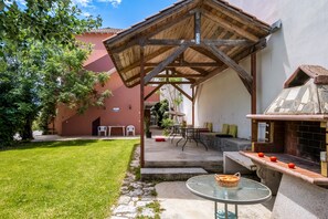 A covered patio area with a table and chairs, a grill, and a small garden. - Apartment "Studio Rea" with Sea View, Garden & Wi-Fi (Lefkada)