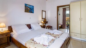 A bedroom with a wooden bed, a nightstand with a lamp, a painting on the wall, and a wardrobe. - Apartment "Studio Rea" with Sea View, Garden & Wi-Fi (Lefkada)
