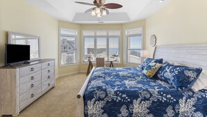 A bedroom with a bed, a dresser, a ceiling fan, and a window with a view. - Makin' Memories! Clean, Comfortable, and Enjoyable! (Ocean Isle Beach)