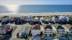 A coastal residential area with houses, a road, and a beach. - Makin' Memories! Clean, Comfortable, and Enjoyable! (Ocean Isle Beach)