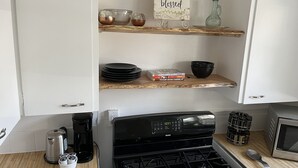 Una cocina con estufa, cafetera y un letrero que dice 'thankful grateful blessed'.