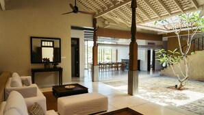 Un vaste espace de vie doté d’un haut plafond, un coin repas offrant une vue agréable et un petit jardin intérieur.