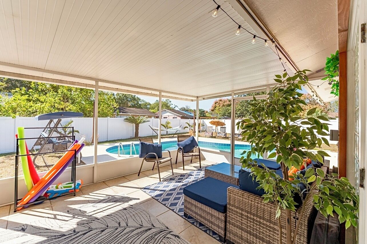 Ett takförsett utomhusområde med en pool, solstolar och en vattenrutschkana.