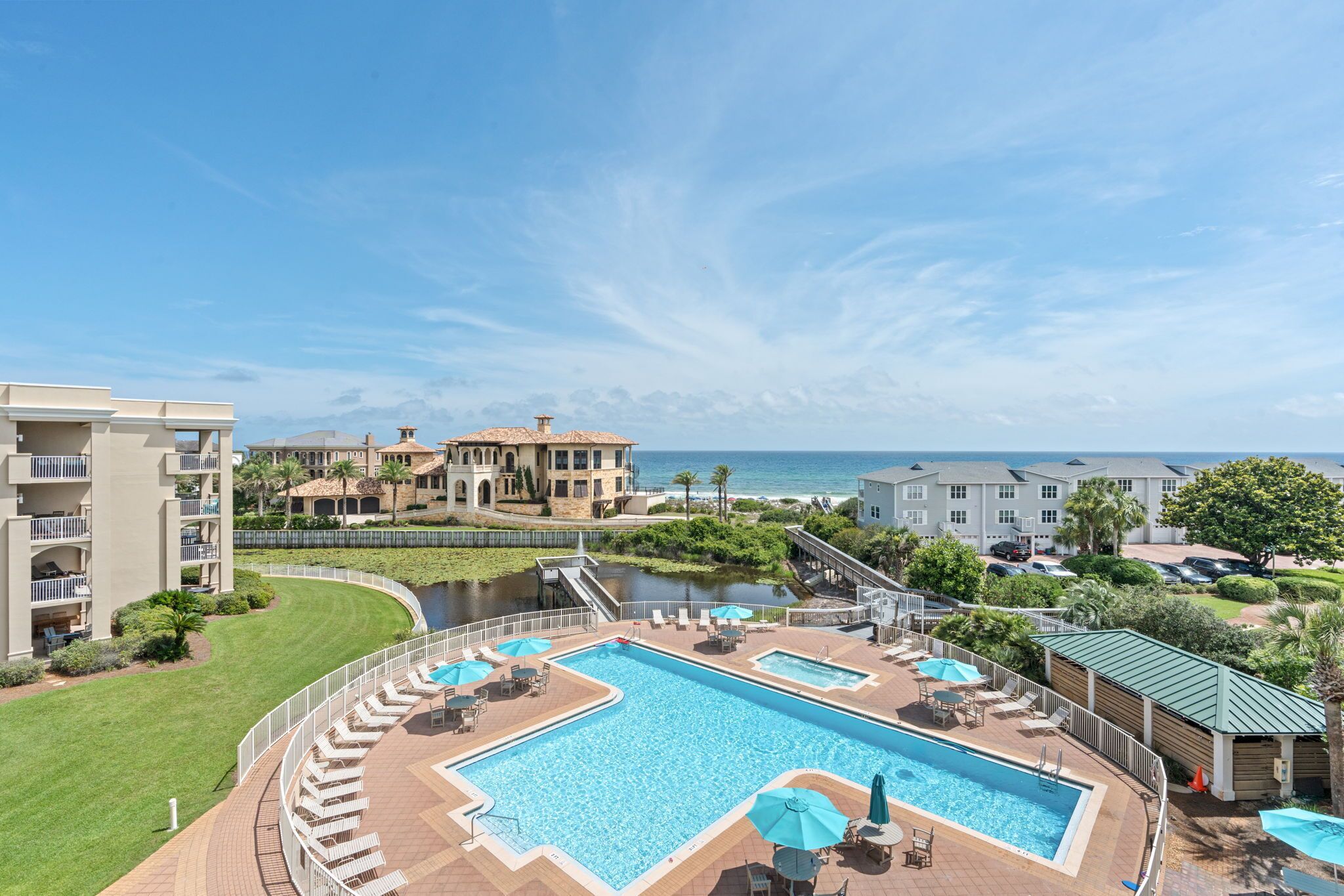 Un resort con una piscina grande, una fuente de agua y vista al océano.