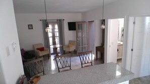 Amplia sala de estar con una mesa de comedor, sillas, un sofá y una cocina con mostrador.