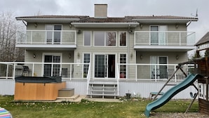 Een tweelaags huis met terras, jacuzzi en glijbaan.