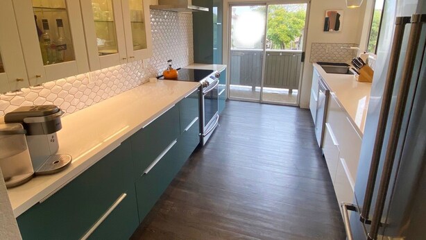 A modern kitchen with a central island, built-in appliances, and a sliding glass door leading to a balcony. - Coastal Condo w/Great Amenities, Walkable to Beach (Dana Point)