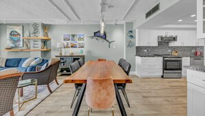A modern kitchen with white cabinets, a black countertop, and a stainless steel oven.