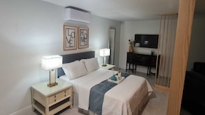 A hotel room with a bed, bedside tables, a desk, and a TV. - Kissimmee Studio 16 min from Disney World (Kissimmee)