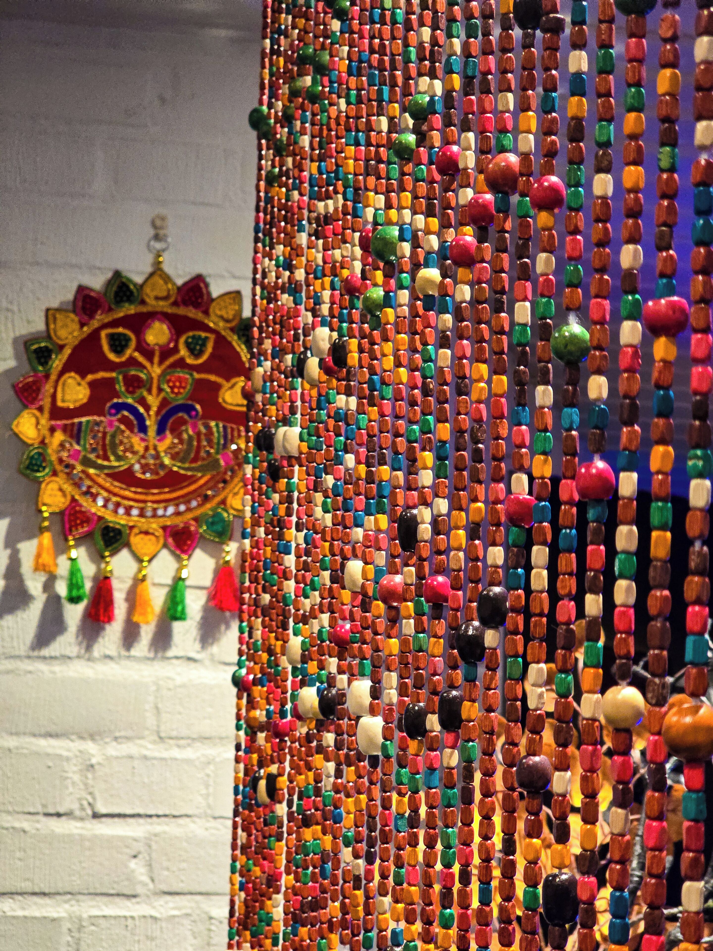 Una pared decorada con cuentas coloridas y un adorno colgante.