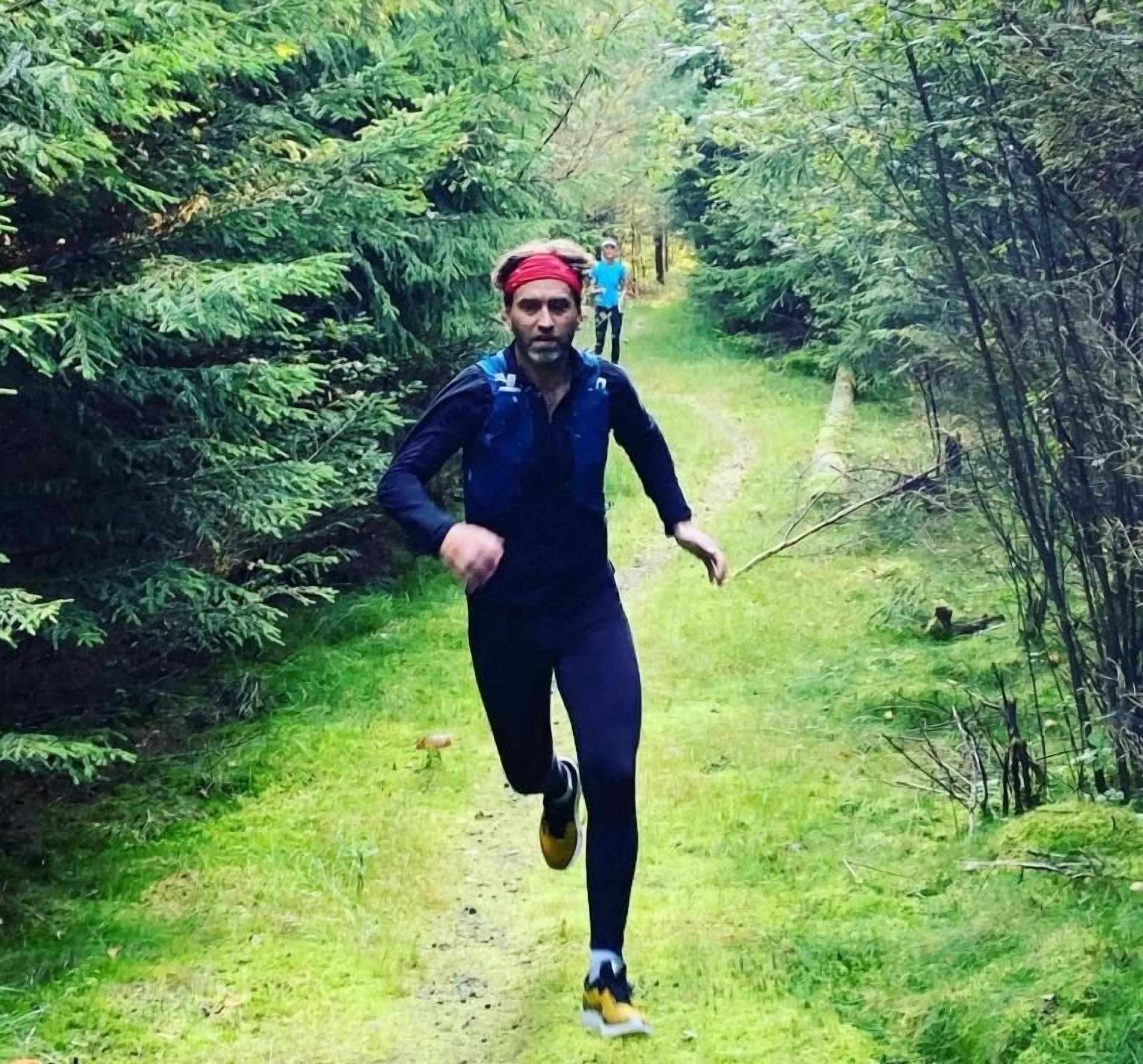 A person running on a forest trail.