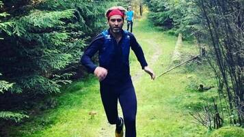 A person running on a forest trail.