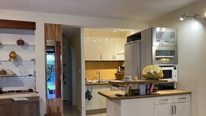 Una cucina moderna con pensili bianchi, un piano di lavoro in legno e un forno a microonde integrato.
