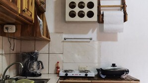 A kitchen with wooden cabinets, a stove, a sink, and a drying rack. - Lara Loft 5 minutes from Juan Santa María Airport (Alajuela)