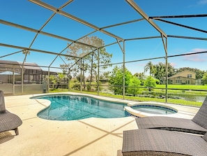Una piscina cubierta al aire libre con sillones de descanso y una vista de una casa al fondo.