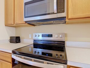 A kitchen with a microwave, toaster, and oven.