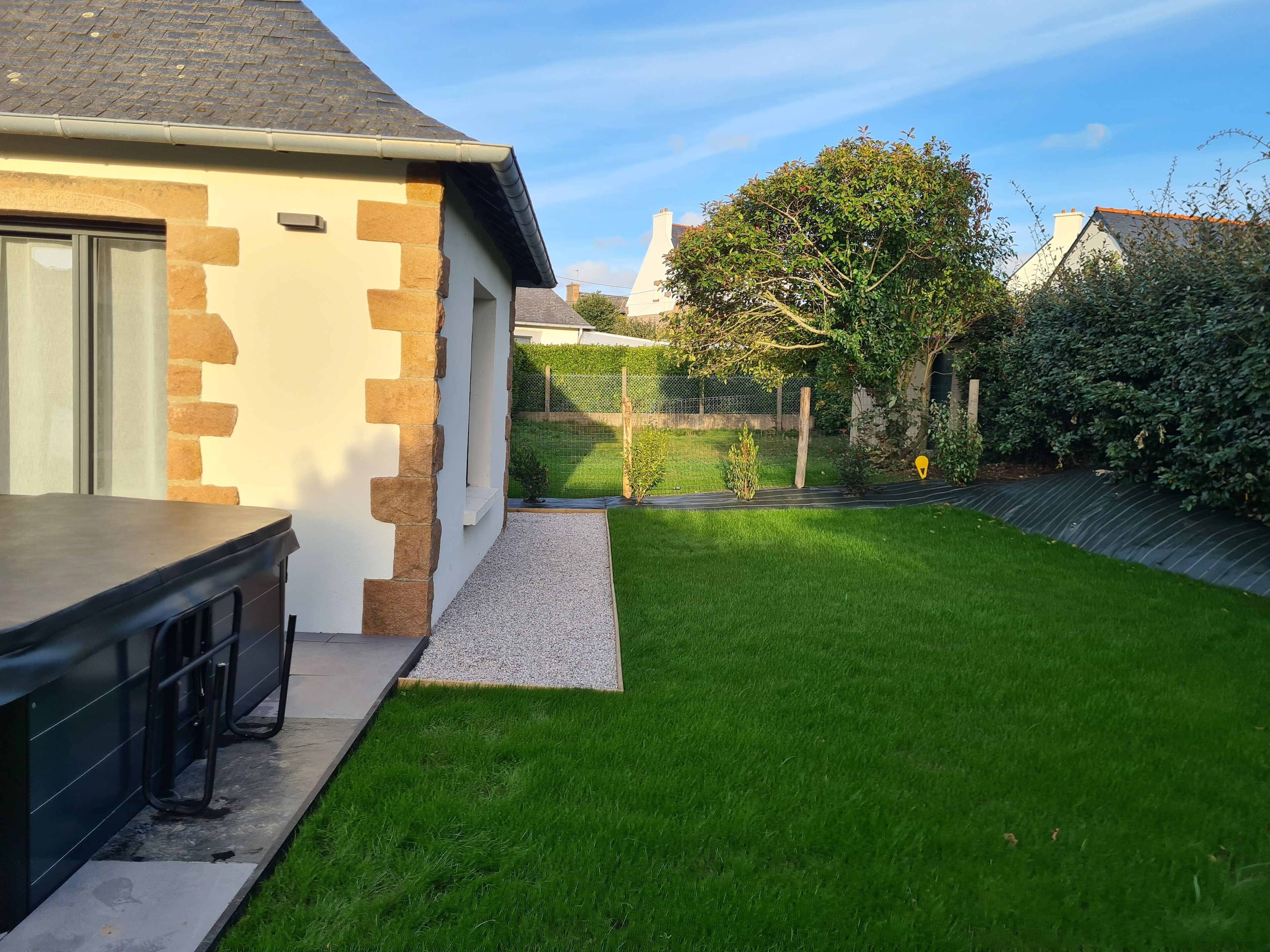 A modern house with a well-maintained lawn and a paved driveway.
