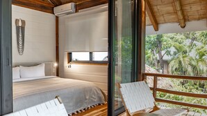 A bedroom with a bed, a window, and a balcony with a chair. - Blue Mist Hotel & Beach Club (Cóbano)