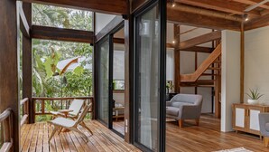 A wooden deck with lounge chairs, a staircase, and a view of greenery. - Blue Mist Hotel & Beach Club (Cóbano)