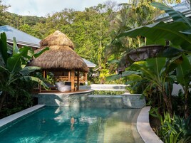Una piscina al aire libre, sillones reclinables de piscina