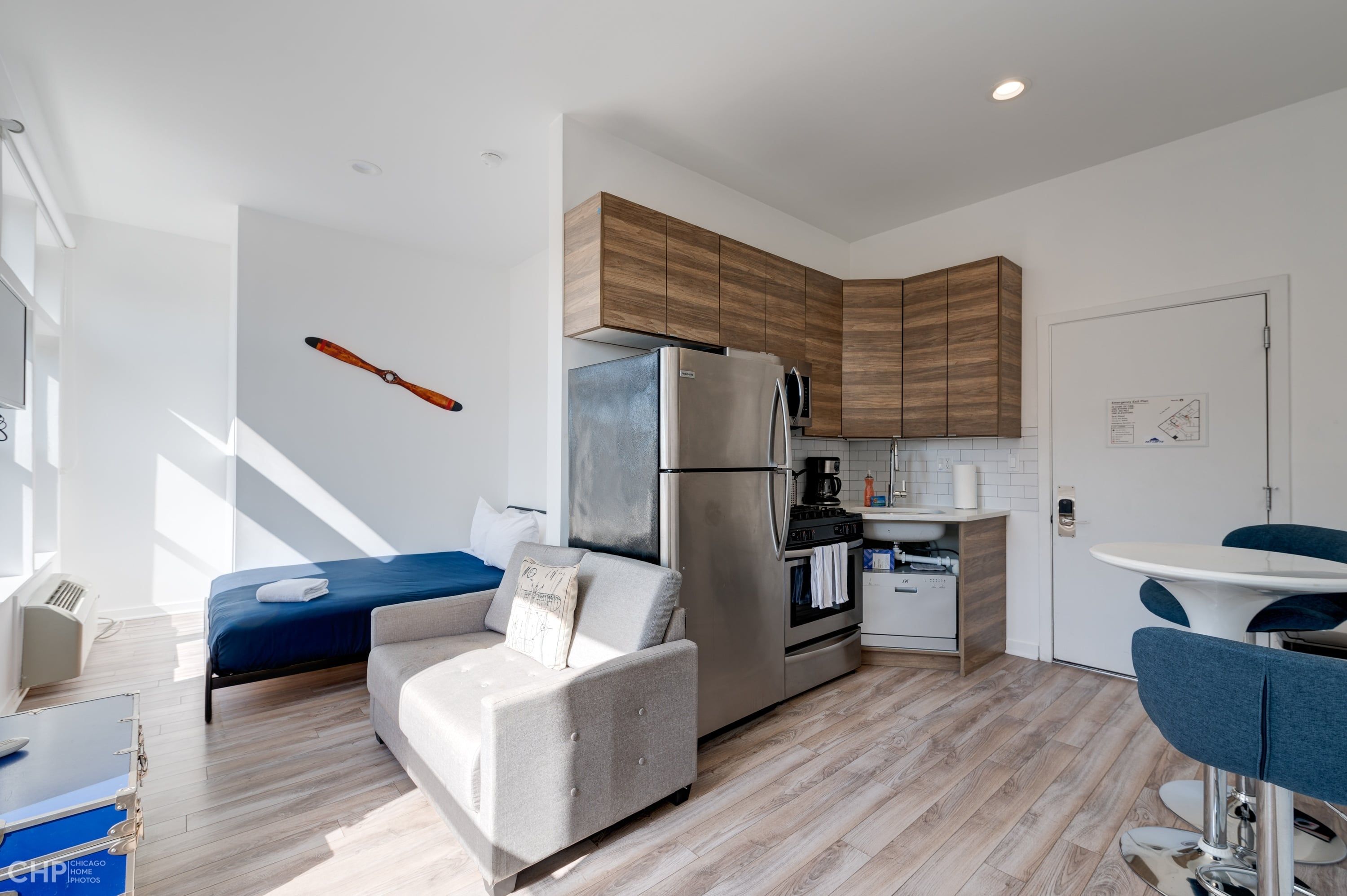 Un apartamento moderno con kitchenette, cama, sofá y zona de comedor.