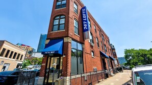 A red brick building with a blue awning and a sign reading "747 LOFTS." - River West, Third Floor Chicago by 747 Lofts (Chicago)