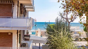 En bygning med flere etager og en balkon med udsigt over en strand.