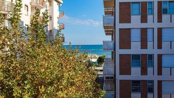 Un immeuble à plusieurs étages doté de balcons et offrant une vue sur la mer.
