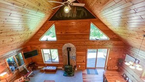 Ein gemütliches Blockhaus mit geneigtem Dach, Kamin und Essbereich.