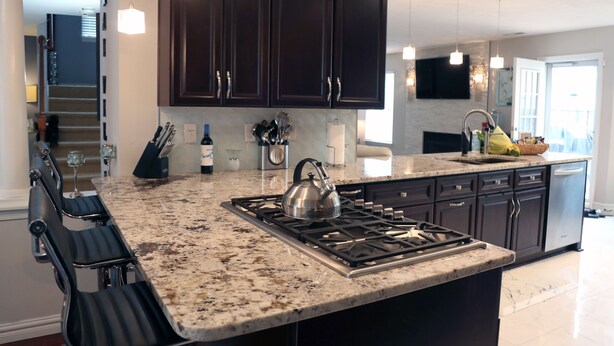 A kitchen with dark cabinets, a granite countertop, a gas stove, and hanging pendant lights. - Mai Villa-Hampton - Where good times happen! (Hampton)