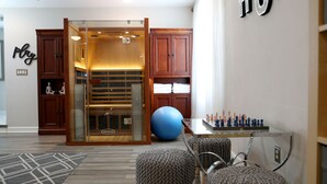 A hotel lobby with a glass partition, wooden cabinets, a large exercise ball, and a chess table. - Mai Villa-Hampton - Where good times happen! (Hampton)