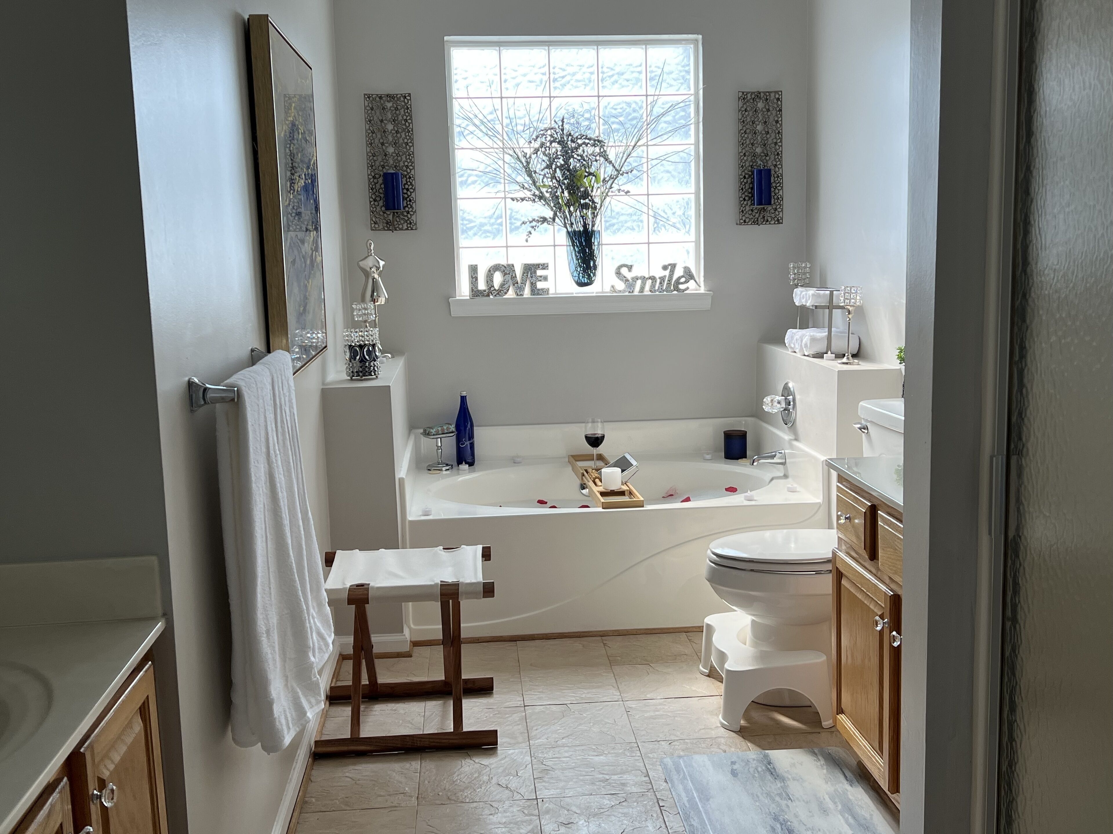 Een moderne badkamer met een vrijstaand bad, een toilet en een wastafelmeubel.
