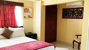 Un dormitorio con cama, mesita de noche, armario y una silla.