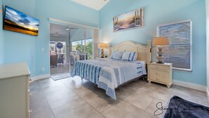 A bedroom with a bed, bedside tables, a ceiling fan, and a window with blinds. - The Blue Lagoon of Naples (Naples)