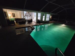 An indoor swimming pool with a clear view of a living area with a sofa and a coffee table. - The Blue Lagoon of Naples (Naples)