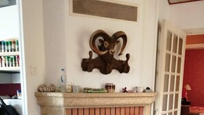 Una habitación con chimenea, un hogar de piedra, una silla y una cesta.