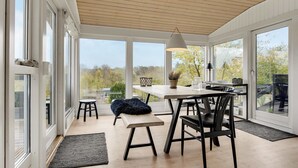 Un espace de restauration moderne avec un plafond en bois, de grandes fenêtres et une vue sur les arbres.