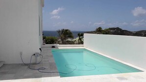A rooftop pool with a clear view of the ocean and hills in the background. - Spectacular view of the Caribbean Sea (Sint Maarten)