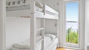 A bunk bed room with a view of a lake through a glass door. - 4 bedroom nice home in Jørpeland (Jørpeland)