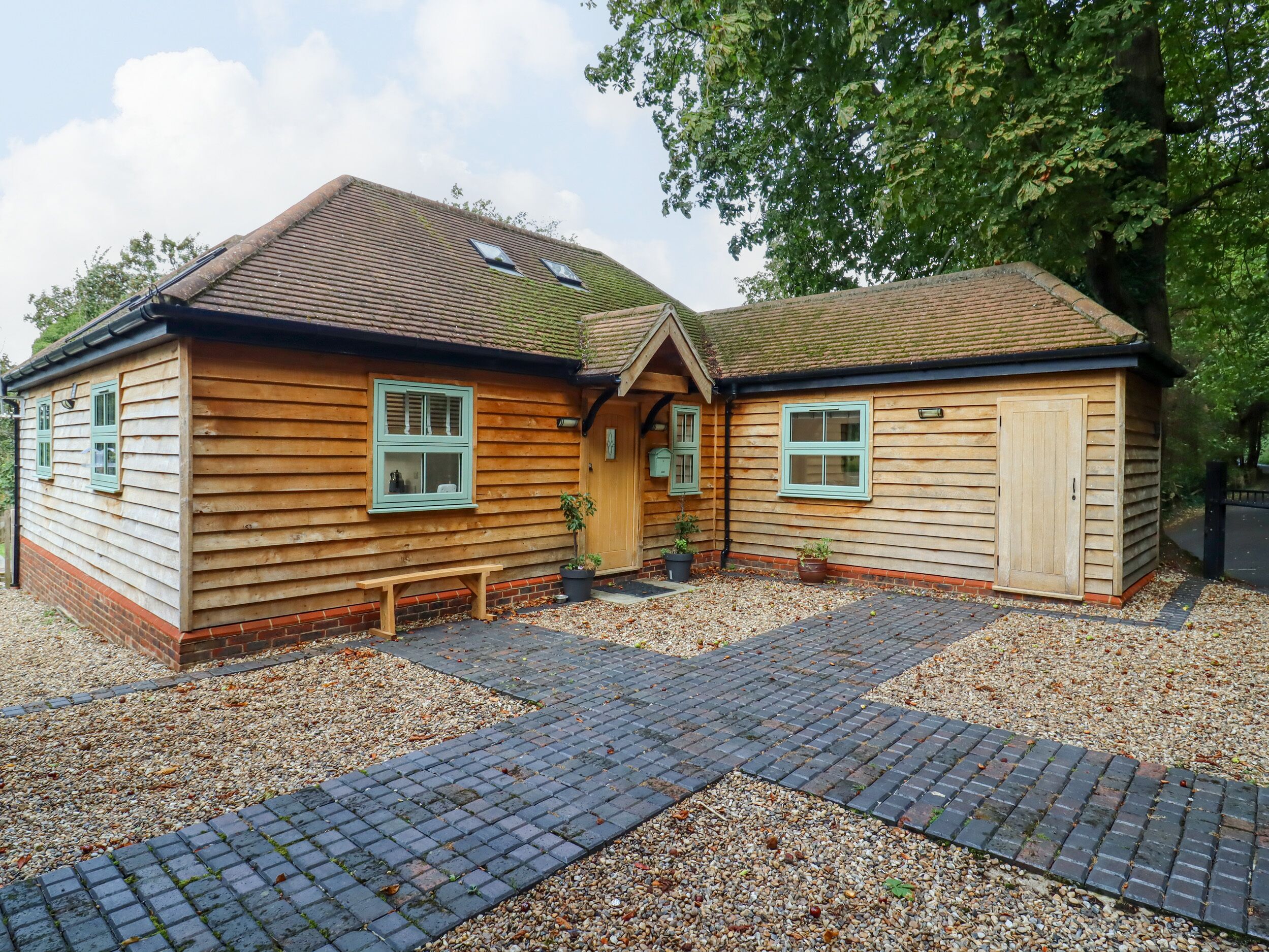 A wooden house with two visible windows, a door, and a small porch area.