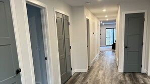 A hallway with grey doors, wooden flooring, and recessed lighting. - Secluded, Cozy Shouse near the Lake!  (Roosevelt)