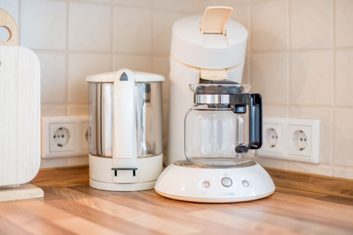 Eine Küche mit Kaffeemaschine, Wasserkocher und Toaster auf einer Holzauskład.