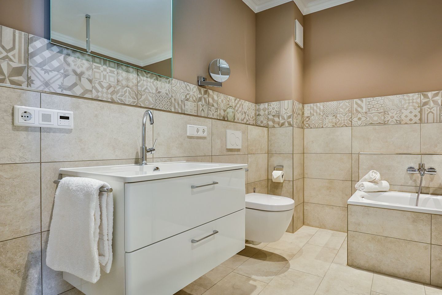 Une salle de bain moderne avec un meuble-lavabo blanc, des toilettes et une baignoire.