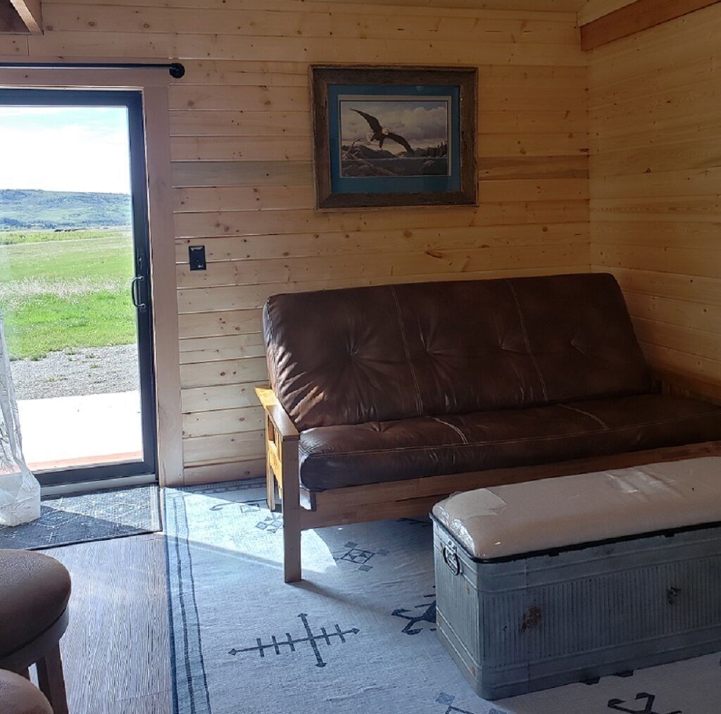 A wooden interior with a leather sofa, a bench, and a small table.