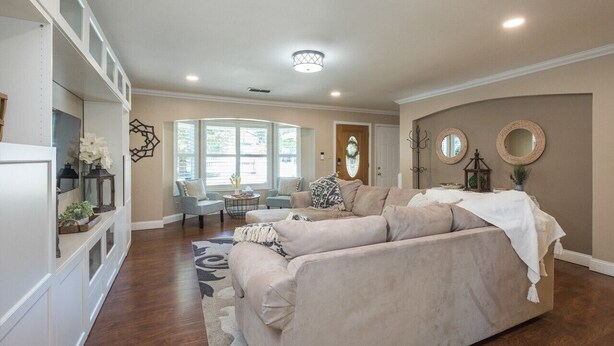 A spacious living room with a beige sofa, a coffee table, and a large window providing natural light. - King Beds! - Clean and Spacious 5 bed 3 bath home (Citrus Heights)
