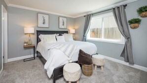 A bedroom with a bed, bedside lamps, a window with curtains, and wall-mounted planters. - King Beds! - Clean and Spacious 5 bed 3 bath home (Citrus Heights)