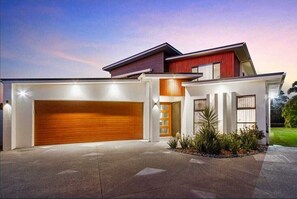 Stylish home with a garage, entrance, and beautifully landscaped yard.
