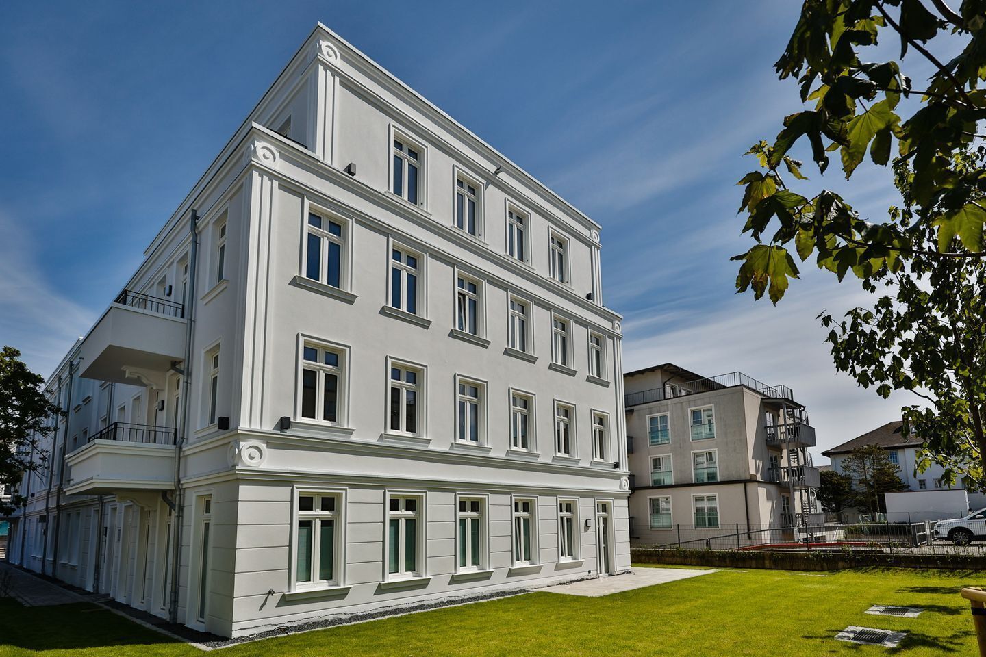 Un immeuble à plusieurs étages, doté d’une façade symétrique, de grandes fenêtres et d’un toit plat.